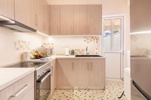 a kitchen with wooden cabinets and a window at Katsanis luxury apt., stunning view of acropolis in Athens