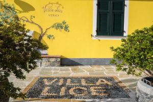 a yellow house with a welcome sign in front of it at Villa Lice Verici in Casarza Ligure