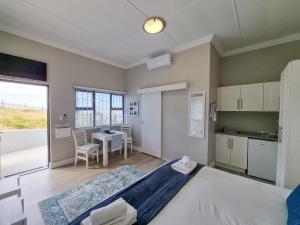 a bedroom with a bed and a kitchen with a table at La Liberté-freedom to be in Piketberg