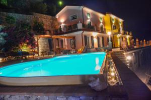 a swimming pool in front of a house at night at Villa Lice Verici in Casarza Ligure
