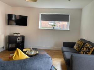 a living room with a couch and a tv at Central Hull Spacious Apartment H3 in Hull