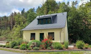 施托爾彭的住宿－Ferienhaus Buschmuehle - Stolpen，一座黄色的小房子,设有太阳能屋顶