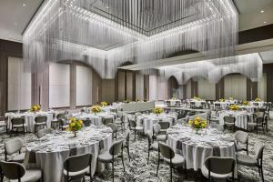伯明翰Daxton Hotel Birmingham, Curio Collection by Hilton的摆放着白色桌椅的宴会厅
