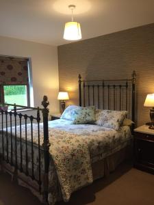 een slaapkamer met een groot bed met een houten hoofdeinde bij Woodvilla Lodge in Kilmore