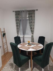 a dining room with a table and green chairs at Exclusive apartment Visoko in Visoko