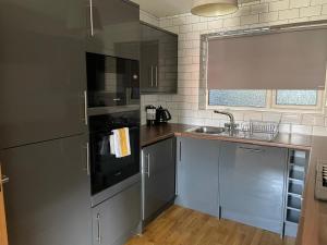 a kitchen with stainless steel appliances and a sink at Central Hull Spacious Apartment H3 in Hull