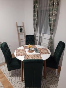 a dining room table with green chairs and a white table at Exclusive apartment Visoko in Visoko