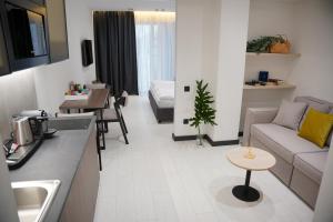 布克維的住宿－BUKA Apart-Hotel & SPA，厨房以及带沙发和桌子的客厅。