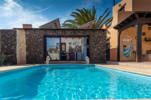 a swimming pool in front of a house at Villa Maravilla piscina climatizada in Villaverde