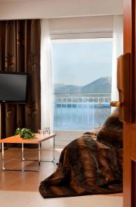 a room with a large window with a view of the ocean at Chloe Luxury Hotel in Kastoria