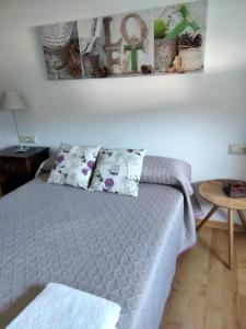 - une chambre avec un lit avec des oreillers et une table dans l'établissement ATICO CALDAS, à Caldas de Reis