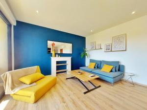 - un salon bleu avec un canapé et une table dans l'établissement Appartement MARLENE - Lumineux - Terrasse - WIFI - Clim - Ajaccio, à Ajaccio