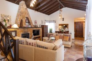a living room with couches and a fireplace at Villa Maravilla piscina climatizada in Villaverde