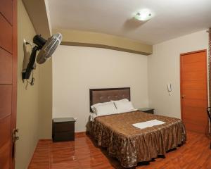 ein Schlafzimmer mit einem Bett und einem Ventilator an der Wand in der Unterkunft Hotel Residencial San Isidro in Hualmay