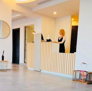 a woman standing at a counter in an office at Hotel VIU57 in Mellieħa