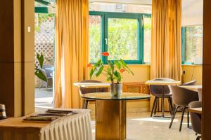 ヴァルフェルダンジュにあるホテル レストラン モリスのテーブルと椅子、窓が備わる客室です。