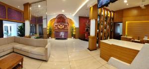 a lobby of a hotel with couches and a large doorway at KTDC Folk Land, Parassinikadavu in Pāppinisseri