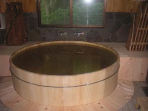 a bath tub sitting inside of a building at Shukubo Komadori-Sanso in Ome
