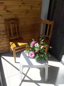 a white table with flowers on it next to two chairs at Guest House Mari30 in Mestia