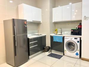 a kitchen with a refrigerator and a washing machine at KL Gateway Residency in Kuala Lumpur