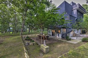 una casa blu nel bosco con tavolo e alberi di Unique Southampton Getaway with Rooftop Deck! a Southampton