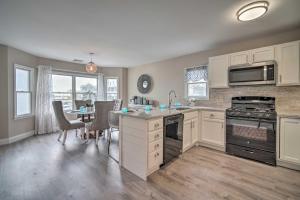 a kitchen with white cabinets and a table with chairs at Modern Atlantic City House Walk to Beach! in Atlantic City