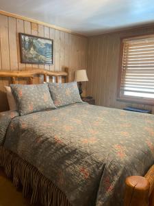 a bedroom with a bed with a comforter on it at Silver Fork Lodge & Restaurant in Brighton