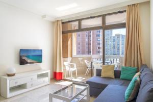 a living room with a couch and a tv at Marina view sunny apartment in Fuengirola