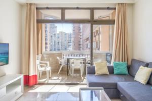 a living room with a couch and a balcony with a table at Marina view sunny apartment in Fuengirola