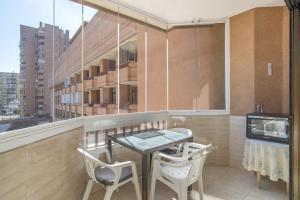 a balcony with a table and two chairs and a television at Marina view sunny apartment in Fuengirola