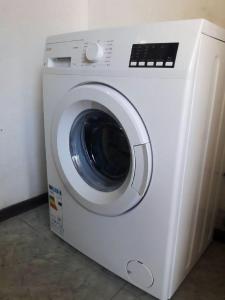 una lavadora blanca junto a una pared en Guest House Mari30 en Mestia