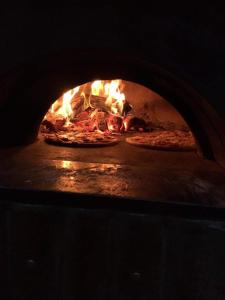 Un horno de fuego con dos pizzas. en Hurstbridge Haven, 
