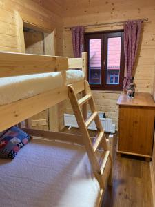 - une chambre avec 2 lits superposés dans une cabane en rondins dans l'établissement chata Derikovo, à Gaboltov