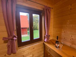 Cette chambre dispose d'une fenêtre dans une cabane en rondins. dans l'établissement chata Derikovo, à Gaboltov