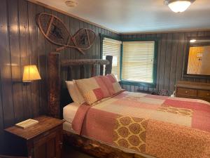 1 dormitorio con 1 cama con pared de madera en Silver Fork Lodge & Restaurant en Brighton