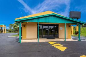 a building with a green roof and a parking lot at Quality Inn White Springs Suwanee in Live Oak