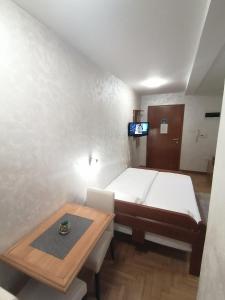ein kleines Zimmer mit einem Bett und einem Tisch in der Unterkunft Zelenkada in Zlatibor + 22 Fotos