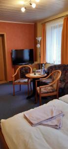 ein Hotelzimmer mit einem Bett, einem Tisch und einem Sofa in der Unterkunft Frühstückspension "Schlösselmühle" in Jöhstadt