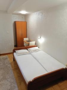 ein Schlafzimmer mit einem großen weißen Bett in einem Zimmer in der Unterkunft Zelenkada in Zlatibor