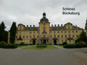 a large yellow building with a clock tower on top at Unterkunft Ramser in Bad Eilsen