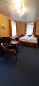 ein Wohnzimmer mit einem Bett und einem Tisch in der Unterkunft Frühstückspension "Schlösselmühle" in Jöhstadt