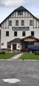 a building with a van parked in front of it at Frühstückspension "Schlösselmühle" in Jöhstadt