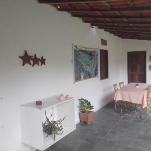 ein weißes Zimmer mit einem Tisch und einem Tisch sidx sidx sidx sidx in der Unterkunft Pousada Praia de Tairu in Armação do Tairu