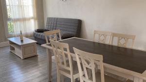 uma sala de estar com uma mesa e cadeiras e um sofá em Spacieux 2 pièces dans l'hyper-centre em Royan