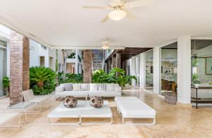 una sala de estar con muebles blancos y plantas en Exclusive Punta Cana Resort and Club Pool Villas, en Punta Cana