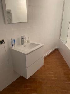 W łazience znajduje się biała umywalka i lustro. w obiekcie Lichtrijk mooi appartement met zicht op hof van Roosendael w Antwerpii