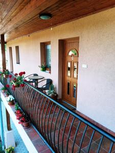 切爾凱瑟勒的住宿－Liliána Apartman，一个带桌子和鲜花的房屋阳台