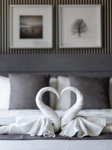 Dos cisnes blancos formando un corazón en una cama en Tropicana 218 Macalister by Simply Penang en George Town