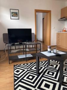 uma sala de estar com uma televisão e uma mesa em Aparthotel Faust em Děčín