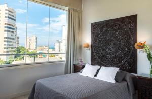 a bedroom with a bed and a large window at Essence Hotel Boutique in Torremolinos